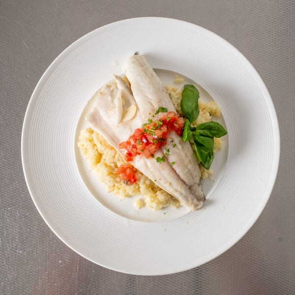 White fish fillets with tomato salsa, basil, and garlic on a bed of risotto.