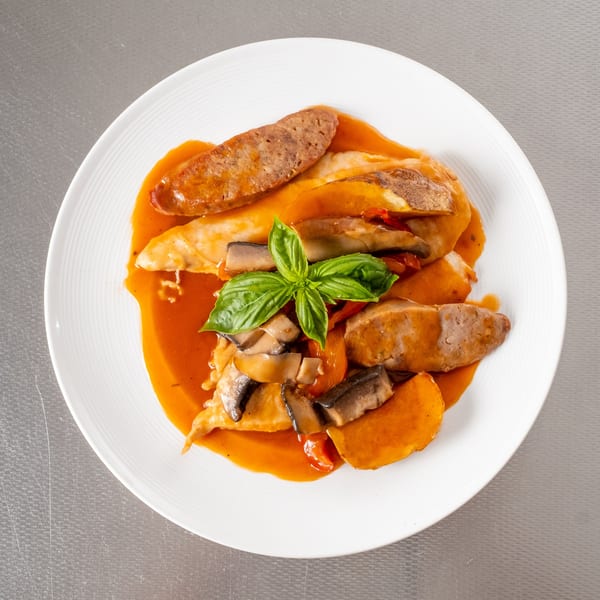 Sausage and chicken with mushrooms, sweet potatoes, and basil in a rich orange sauce.